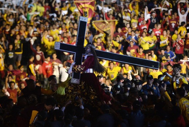 Devotees try to touch the life-sized Black Nazarene statue during the annual religious procession in honour of the Black Nazarene in Manila on January 9, 2016. Barefoot men and women in search of miracles hurled themselves above huge crowds in the Philippines on January 9 to touch a centuries-old icon of Jesus Christ as one of the world's largest Catholic festivals got under way.  AFP PHOTO / TED ALJIBE / AFP / TED ALJIBE
