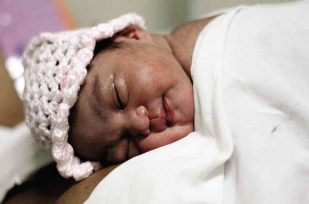 NEW YEAR BABY Kashmyr Mancilla smiles as she sleeps on the chest of her mother Mary Ann at the Dr. Jose Fabella Memorial Hospital in Manila. The baby was born at 12:01 a.m. on Jan. 1. RICHARD A. REYES