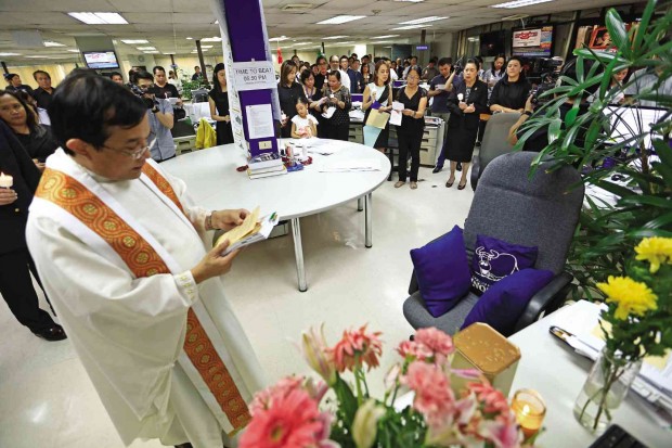 FINAL BLESSING   Fr. Rey Reyes reads a prayer to bless the work table of Inquirer editor in chief Letty Jimenez-Magsanoc after a memorial Mass on Thursday at the newsroom where she held sway for 25 years. 