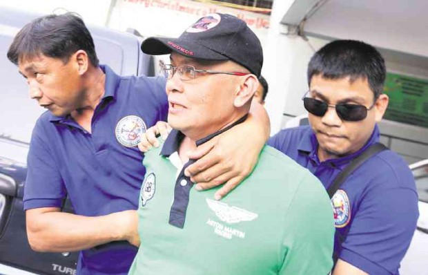 BUSTED Narcotics agents lead away Lt. Col. Ferdinand Marcelino, a former PDEA official, after his arrest in a  drug raid in Santa Cruz, Manila, on Thursday.  NIÑO JESUS ORBETA