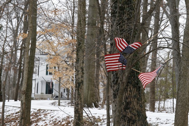 Small American flags have been placed in the trees in front of the Warmbier family home, Friday, Jan. 22, 2016, in Wyoming, Ohio. North Korea on Friday announced the arrest of Otto Warmbier, a university student from Ohio, for what it called a "hostile act" orchestrated by the American government to undermine the authoritarian nation. (AP Photo/Gary Landers)