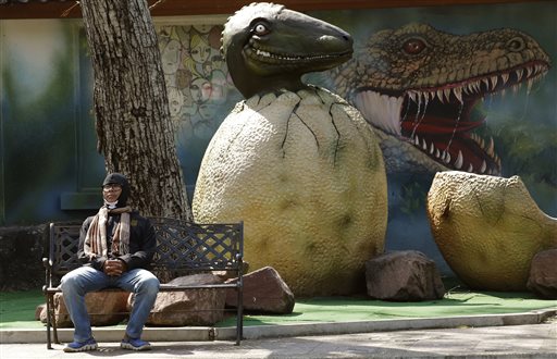 A Thai visitor wearing a scarf and a jacket sits on a bench at Dusit Zoo in Bangkok, Thailand, Tuesday, Jan. 26, 2016. January is the most wintry season for much of Asia, but few people were prepared for the sudden drop in temperatures that sent them scurrying this past weekend for coats and scarves. In the Thai capital Bangkok, where temperatures hit an unseasonably high 34 degrees C  (93 F)  this past Saturday, only to bottom out to a low of  15 degrees C (59 F) on Monday. (AP Photo/Sakchai Lalit)