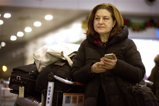 French journalist Ursula Gauthier, a reporter in China for the French news magazine L'Obs, checks her cellphone as she waits at Bejing Capital International Airport in Beijing, Thursday, Dec. 31, 2015. Gauthier is leaving China after being denied press credentials and facing heavy criticism from the Foreign Ministry and state media over her reporting, becoming be the first foreign journalist forced to leave China since 2012, when American Melissa Chan, then working for Al Jazeera in Beijing, was expelled. (AP Photo/Mark Schiefelbein)