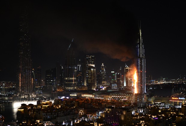 Smoke and flames pouring from a residential building, which also contains the Address Downtown Hotel, in Dubai, United Arab Emirates, Thursday evening, Dec. 31, 2015.  (Sina Bahrami/@dearsina via AP) MANDATORY CREDIT