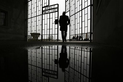 A man enters the Sachsenhausen Nazi death camp through the gate with the phrase 'Arbeit macht frei' (work sets you free) at the International Holocaust Remembrance Day, in Oranienburg, about 30 kilometers, (18 miles) north of Berlin, Wednesday, Jan. 27, 2016. The International Holocaust Remembrance Day marks the liberation of the Auschwitz Nazi death camp on Jan. 27, 1945. (AP Photo/Markus Schreiber)