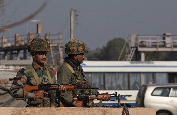 Indian army soldiers take positions outside the Indian airbase in Pathankot, 430 kilometers (267 miles) north of New Delhi, India, Saturday, Jan. 2, 2016. At least four gunmen entered an Indian air force base near the border with Pakistan on Saturday morning and exchanged fire with security forces, leaving two of them dead, officials said. (AP Photo/Channi Anand)