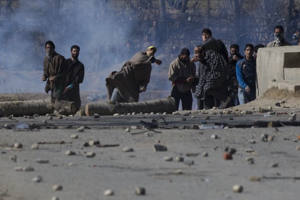 Kashmiri Muslim protesters throw stones as they clash with Indian police men in Naina village some 40 kilometers (25 miles) south of Srinagar, Indian controlled Kashmir, Wednesday, Jan. 20, 2016. Violent clashes between police and protesters erupted Wednesday in Indian-controlled Kashmir, leaving a man dead and two others wounded, officials said. (AP Photo/Dar Yasin)