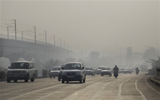 Vehicles move through morning smog on the first day of a two-week experiment to reduce the number of cars to fight pollution in New Delhi, India, Friday, Jan. 1, 2016. The volunteers are meant to encourage people to fall in line with the government’s plan to allow private cars on the roads only on alternate days from Jan. 1-15, depending on whether their license plates end in an even or an odd number. (AP Photo/Altaf Qadri)