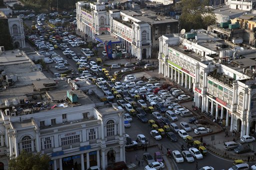 Cars and autorickshaws move through the central Connaught Place area in New Delhi, India, Thursday, Dec. 24, 2015. The Indian capital, gasping and choking under record-high air pollution, announced a grand plan to clean its air. But that plan seems to be fizzling before it starts.(AP Photo/Tsering Topgyal)