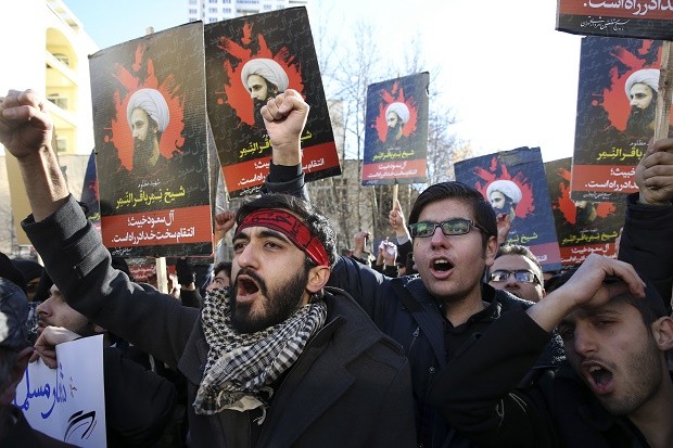 Iranian demonstrators chant slogans during a protest denouncing the execution of Sheikh Nimr al-Nimr, a prominent opposition Shiite cleric in Saudi Arabia, seen in posters, in front of the Saudi Embassy, in Tehran, Sunday, Jan. 3, 2016. Saudi Arabia announced the execution of al-Nimr on Saturday along with 46 others. His execution drew condemnation from Shiites across the region. (AP Photo/Vahid Salemi)