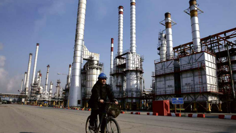 OIL EMBARGO ENDS An Iranian oil worker rides past Tehran’s oil refinery following a historic nuclear deal between Iran and world powers. The deal means an end to a European oil embargo on the world’s seventh largest oil producer. AP