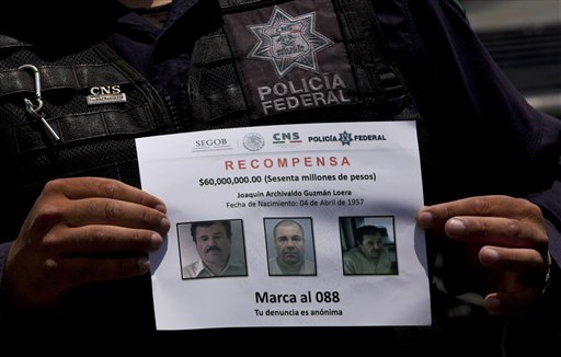 In this July 16, 2015 file photo, a Federal Police shows a reward notice for information leading to the capture of drug lord Joaquin "El Chapo" Guzman, who made his escape from the Altiplano maximum security prison via an underground tunnel,  in Almoloya, west of Mexico City. Mexican President Enrique Pena Nieto posted on his Twitter account, Friday, Jan. 8, 2016, that drug lord Joaquin 'Chapo' Guzman has been recaptured.(AP Photo/Marco Ugarte, File)