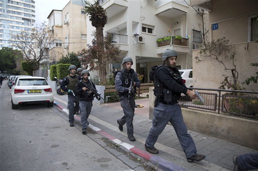 Israelis police officers search for a gunman near the scene of a shooting attack in Tel Aviv, Israel, Friday, Jan. 1, 2016. A gunman opened fire at a popular bar in the central Israeli city, killing two and wounding at least three others before fleeing the scene, police said. (AP Photo/Oded Balilty)