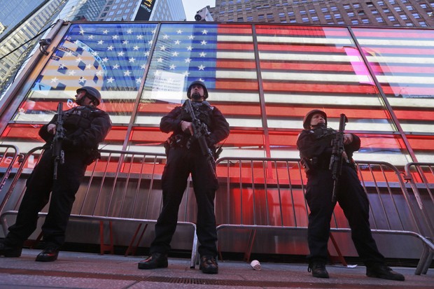 FILE- In this Nov. 14, 2015 file photo, heavily armed New York city police officers with the Strategic Response Group stand guard at the armed forces recruiting center in New York's Times Square. With the nation still jittery over shooting massacres in California and Paris, New York City officials sought to assure revelers Tuesday, Dec. 29, 2015, that the New Year's Eve celebration in Times Square will be the safest place in the world  heavily secured by thousands of New York Police Department officers, including a new specialized counterterrorism unit. (AP Photo/Mary Altaffer, File)