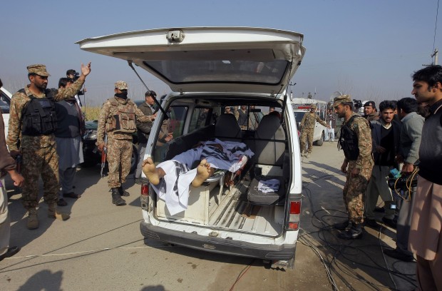 Pakistani troops clear way for an ambulance transporting a lifeless body of a victim from Bacha Khan University in Charsadda town, some 35 kilometers (21 miles) outside the city of Peshawar, Pakistan, Wednesday, Jan. 20, 2016. Gunmen stormed Bacha Khan University named after the founder of an anti-Taliban political party in the country's northwest Wednesday, killing many people, officials said. (AP Photo/Mohammad Sajjad)