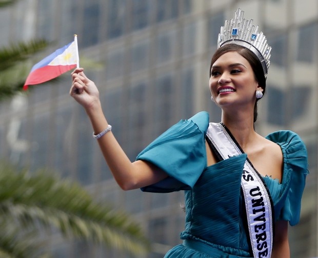Newly crowned Miss Universe Pia Alonzo Wurtzbach waves a Philippine flag as her float passes by the financial district of Makati city east of Manila, Philippines for a victory parade Monday, Jan. 25, 2016. Wurtzbach was crowned Miss Universe Dec. 20, 2015 but not before pageant host Steve Harvey incorrectly announced Miss Colombia as the winner at the Miss Universe pageant  in Las Vegas. Thousands of Filipinos lined the parade route to take a glimpse of the third Filipino to be crowned Miss Universe. (AP Photo/Bullit Marquez)