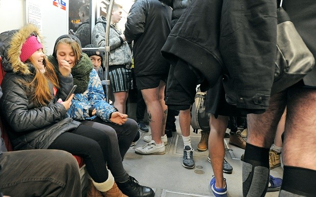 Two girls react as people in underpants taking part in the 'No Pants Subway Ride" event stand next to them in an underground train car in Warsaw, Poland, Sunday, Jan. 10, 2016.  The "No Pants Subway Ride" began in 2002 in New York as a stunt and has taken place in cities around the world since then. (AP Photo/Alik Keplicz)