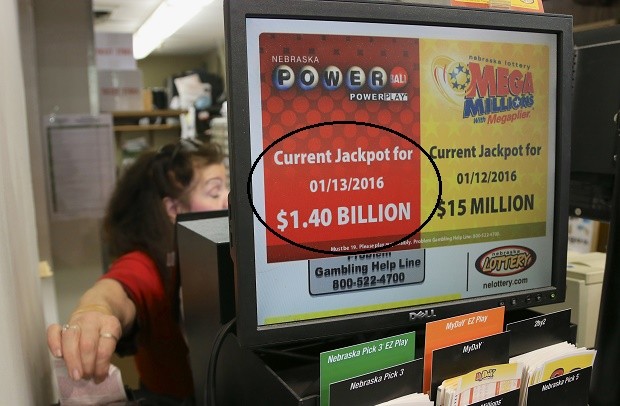A worker at Russ's Market in Lincoln, Neb., reaches for a Powerball ticket Monday, Jan. 11, 2016. The Powerball jackpot has grown to over a billion dollars, and the drawing is still two days away. (AP Photo/Nati Harnik)