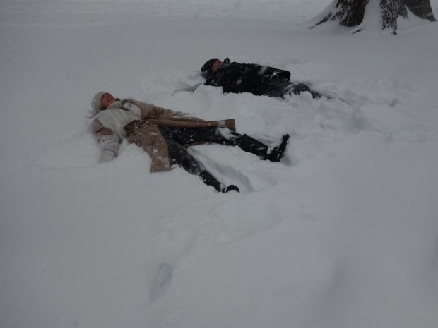 Two people lying in snow