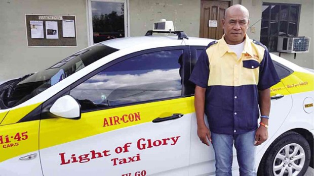 Anselmo Nava stands next to the taxi unit that he drives in Iloilo. He has been hailed for returning a bag containing P300,000 in euros to its owner and received P10,000 in reward which, he said, he used on food for the holidays. NESTOR P. BURGOS / INQUIRER VISAYAS