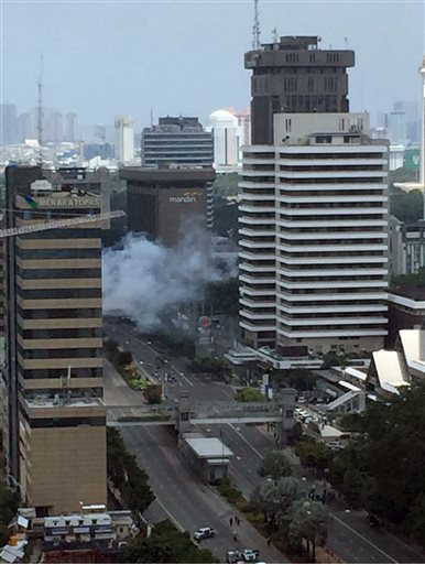 Smoke billows from an explosion in Jakarta, Indonesia, Thursday, Jan. 14, 2016. Suicide bombers exploded themselves in downtown Jakarta on Thursday while gunmen attacked a police post nearby, a witness told The Associated Press. Local television reported more explosions in other parts of the city. (Christian Hubel via AP) 