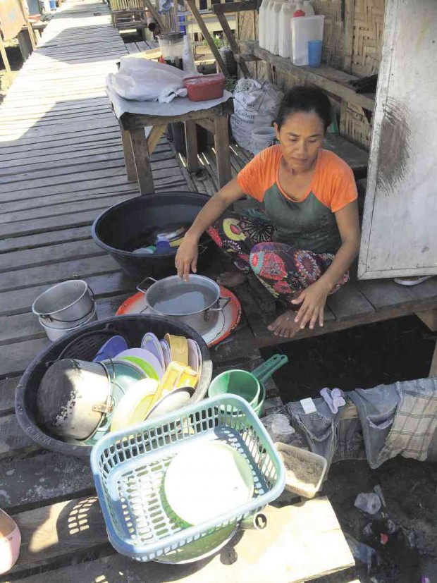 AN EVACUEE has only a pot of water to wash her dishes. Thousands of people displaced by the 2013 siege of Zamboanga City by Moro National Liberation Front rebels are staying in temporary shelters and are affected by water rationing in the city. JULIE ALIPALA/INQUIRER MINDANAO