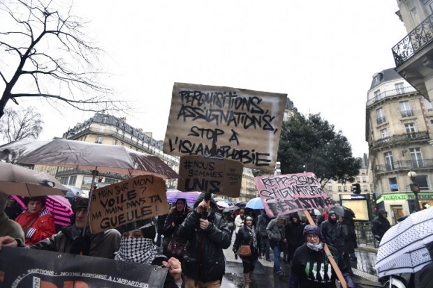 People holding placards reading "searches, summons, stop to the islamophobia" take part in a demonstration on January 30, 2016 in Paris, to protest against government plans to extend a state of emergency for another three months after the November terror attacks in Paris as well as plans to enshrine some of these measures in the constitution. / AFP / ALAIN JOCARD