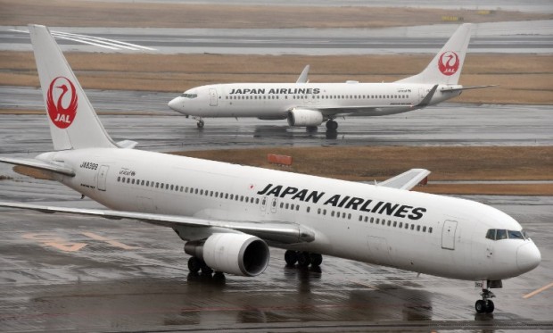 Japan Airlines passenger planes are seen on the runway at Haneda airport in Tokyo on January 29, 2016. Japan Airlines announced its 9-month profit soared 20 percent, as the carrier benefited from a surge in tourism and low fuel costs.     AFP PHOTO / Toru YAMANAKA / AFP / TORU YAMANAKA