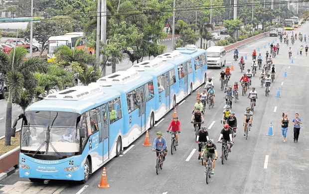 COEXISTENCE  The hybrid road train developed by the DOST runs on its designated lane next to those allotted for bikers during Sunday’s road-sharing demonstration on Roxas Boulevard. MARIANNE BERMUDEZ