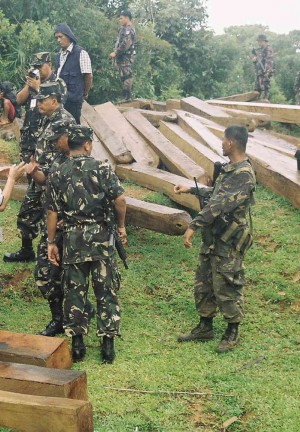 SOLDIERS watch over seized lumber from the Sierra Madre mountain ranges in Quezon province in this 2005 photo.  DELFIN T.      MALLARI JR./INQUIRER SOUTHERN LUZON 