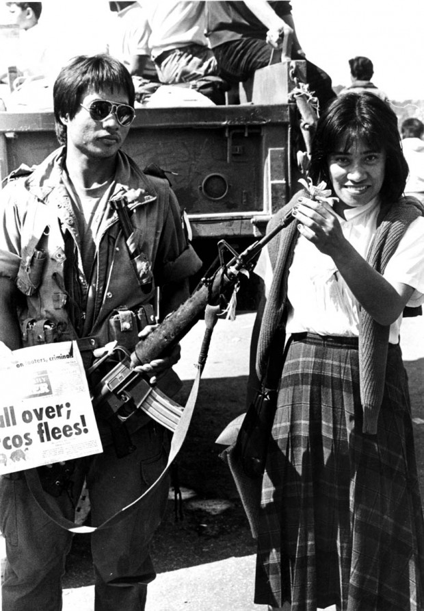 PEOPLE POWER EDSA 1 / FEBRUARY 1986 / SAVED IN PDI ARCHIVE Unidentified woman puts a flower on a firearm of a soldier as people celebrate after Marcos, who ruled for twenty years as one of the world's most powerful dictators, fled to Hawaii. PDI PHOTO