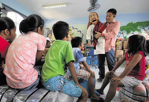 Laughter yoga guru Paolo Trinidad turns into a ventriloquist using his Jesus puppet to spread hope among children displaced by a recent fire.  Photos by RAFFY LERMA