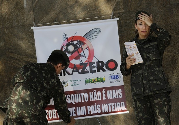 Army soldiers set up a sign that reads in Portuguese "A mosquito is not stronger than an entire country" at the Central station in Rio de Janeiro, Brazil, Saturday, Feb. 13, 2016. More than 200,000 army, navy and air force troops are fanning out across Brazil to show people how to eliminate the Aedes aegypti mosquito that spreads the Zika virus, which many health officials believe is linked to severe birth defects. The nationwide offensive is part of President Dilma Rousseff's declared war on the virus that has quickly spread across the Americas. (AP Photo/Silvia Izquierdo)