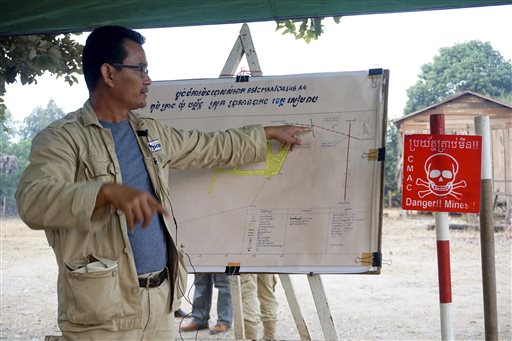In this Feb. 19, 2016, photo, Theap Bunthourn, operations coordinator, describes the land mine threat around the village of Trach, Cambodia. More than 15 people have been killed or injured in mine blasts. (AP Photo/Denis Gray)