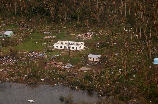 In this Sunday, Feb. 21, 2016 aerial photo supplied by the New Zealand Defense Force, debris is scattered around damaged buildings at Muamua on Vanua Blava Island in Fiji, after Cyclone Winston tore through the island nation. Fijians were finally able to venture outside Monday after authorities lifted a curfew but much of the country remained without electricity in the wake of a ferocious cyclone that left at least six people dead and destroyed hundreds of homes. (New Zealand Defense Force via AP) EDITORIAL USE ONLY