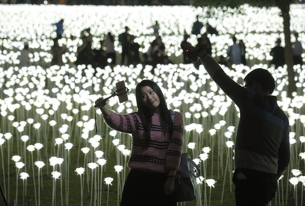 A woman takes a selfie in front of the LED lights roses at the “Light Rose Garden” in Hong Kong, Saturday, Feb. 13, 2016. “Light Rose Garden" is originated from South Korea, an art installation project featuring 25,000 white roses made of LED lights for Valentine’s Day. (AP Photo/Kin Cheung)