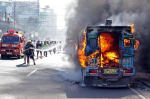 A fireman hose down a jeepney that caught fire on a busy street in Cebu City. (Photo by Lito Tecson, CEBU DAILY NEWS