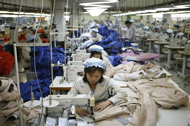 FILE - In this Dec. 19, 2013, file photo, North Korean workers assemble jackets at a factory of a South Korean-owned company at the jointly-run Kaesong Industrial Complex, in Kaesong, North Korea. South Korea says Wednesday, Feb. 10, 2016 it will halt operations at joint industrial park with North Korea in response to the North's recent rocket launch. (Kim Hong-Ji/Pool Photo via AP, File)