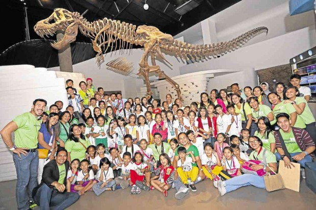 JURASSIC FUN. San Antonio Elementary School students and Capable’s officers and volunteers pose under the museum’s dinosaur skeleton.