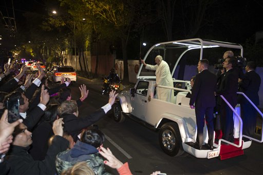 Pope Francis waves to people from the popemobile along his route to the Apostolic Nunciature, the Vatican's diplomatic mission, in Mexico City, Friday, Feb. 12, 2016. The pontiff is in Mexico for a week-long visit. (AP Photo/Christian Palma)