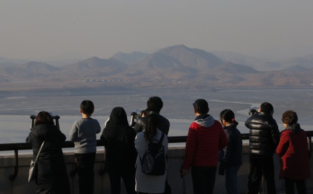 Visitors use binoculars to see the North Korean territory from the unification observatory in Paju, South Korea, Wednesday, Feb. 10, 2016. South Korea said Wednesday that it would suspend operations at a joint industrial park with North Korea in response to the North's recent rocket launch, the first time in the park's decade of operation that Seoul has halted work there. (AP Photo/Lee Jin-man)