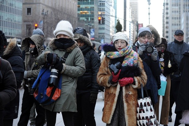Street photographers brave the cold to photograph guests arriving to the Alexander Wang Fall 2016 show during Fashion Week, Saturday, Feb. 13, 2016, in New York. With temperatures continuing to drop throughout the day Saturday, Mayor Bill de Blasio urged New Yorkers to stay safe and warm by limiting time outdoors, reporting heat and hot water conditions to 311, and checking in on vulnerable friends, relatives and neighbors.  (AP Photo/Diane Bondareff)