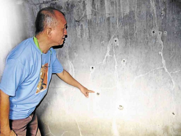 Bernie Salcedo, who was with Evelio Javier when Javier was attacked, points to bullet holes on the wall of a bathroom in a house where the then anti-Marcos opposition leader in Antique was finished off by assassins.    NESTOR P. BURGOS JR