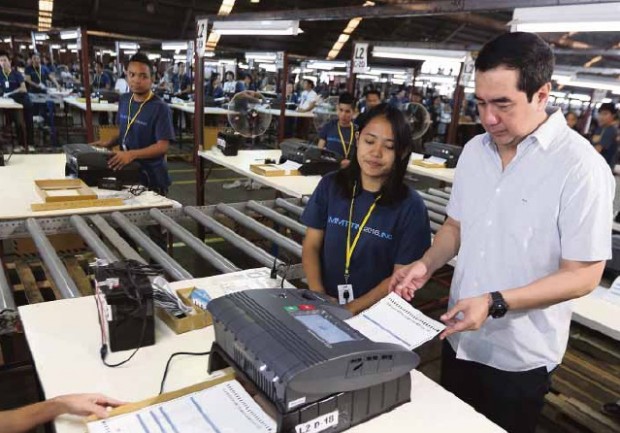Commission on Elections Chair Andres Bautista tries out a countingmachine stored in a Comelec warehouse in Sta. Rosa, Laguna province, during a walk-through. NIÑO JESUS ORBETA/ INQUIRER FILE PHOTO