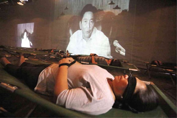 In “The Hall of Restless Sleep,” TV screens show the dictator announcing the declaration of martial law as people lie in slumber. Photos by RAFFY LERMA