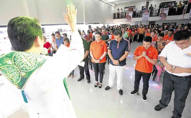 Tolosa, Leyte province, parish priest Msgr. Alex Opiniano leads a prayer for senatorial candidate and Leyte Rep. Martin Romualdez (second from right) and wife, first district congressional candidate Yedda Romualdez (third from right) at a community center in Tacloban City.    CONTRIBUTED PHOTO