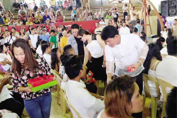 MAYOR Jose Cuyos (right, in Barong Tagalog) of Rosario, Agusan del Sur province, and his wife and running mate, Juvy (second from right), greet newly married couples as the mayor handed them cash gifts. CHRIS V. PANGANIBAN / INQUIRER MINDANAO
