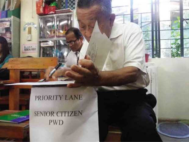 EARLY BIRD  Melchor Romero, 76, the first voter in line as precincts opened in Dagupan City for the nationwide mock polls on Saturday, casts his vote.     WILLIE LOMIBAO / INQUIRER NORTHERN LUZON