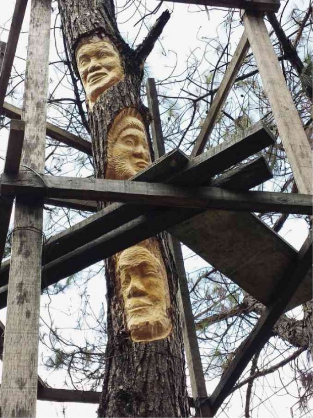 Baguio artist Wigan carved the faces of three Baguio women who fought to save the city’s trees and landscape on a dead tree trunk outside the Baguio Museum. EV ESPIRITU/INQUIRER NORTHERN LUZON