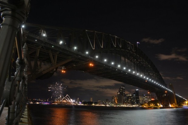 Fireworks fade as lights go out on the Sydney Harbour Bridge and Opera House to signal the start of the Earth Hour environmental campaign, among the first landmarks around the world to dim their lights for the event on March 28, 2015. Lights will go out in some 7,000 cities and towns from New York to New Zealand for Earth Hour to raise awareness of the need for sustainable energy use, and this year also to demand action to halt planet-harming climate change. AFP PHOTO/Peter PARKS / AFP / PETER PARKS